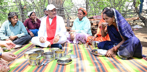 During the inspection of the under-construction Panchayat Bhawan, workers invited the Chief Minister for a meal: They sat together and ate Bore Basi and Aama Chutney.